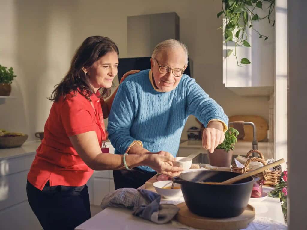 Caregiver and senior preparing a nutritious home-cooked meal together